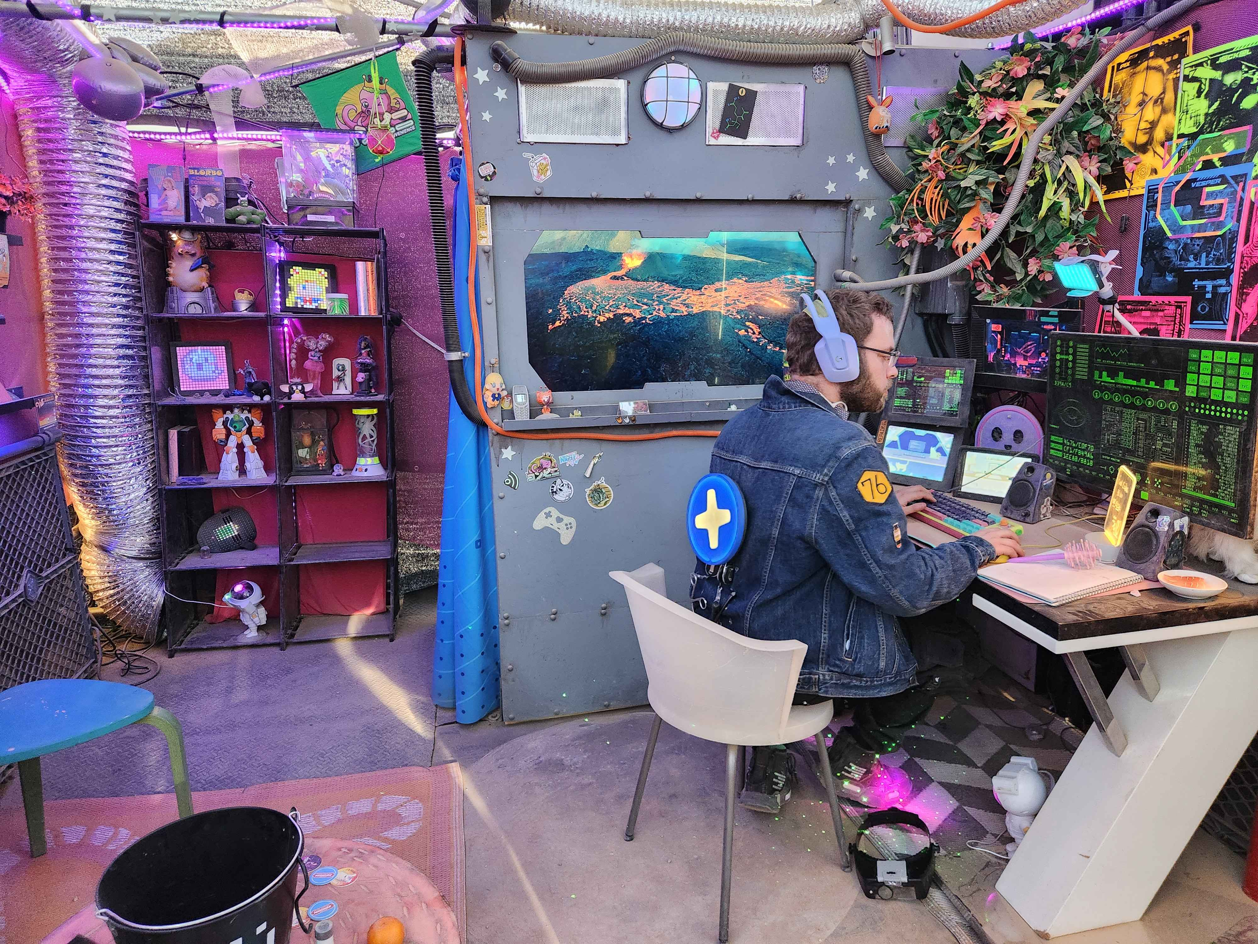 Photo of our first highlighted maker, Evan Brand, sitting at a desk in a colorful room