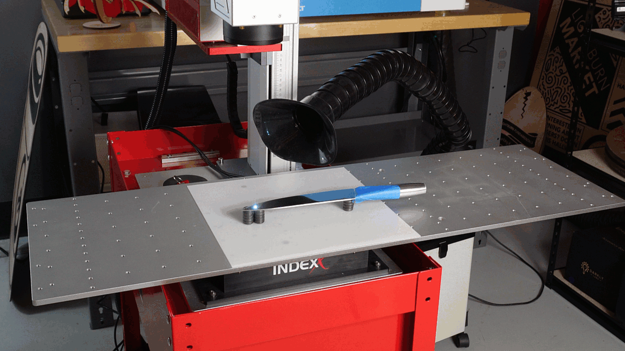 A laser marking a knife using a Split Marking table
